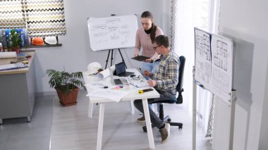 Kadın bir muhasebeci proje tahmini hakkında bir tasarım mühendisiyle konuşur. Baş mimar yeni bir modern bina tasarlıyor. İnşaat şirketinde çalışıyordum.