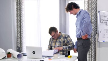 Genç bir avukat bir dosya dolusu belge ile meslektaşına yaklaştı. Gözlüklü sıradan bir işçi bir sürü belgeye bakar. Üzerinde çizimler olan beyaz bir tahtanın önünde iki adam duruyor..