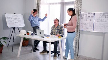 Mutlu bir mimar grubu ihaleyi kazanmasını kutluyor. Bir grup genç bir konferans odasında çalışıyor. İnşaat bürosu. Personel gülümsüyor.