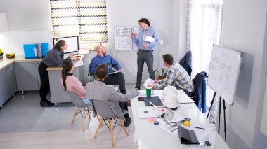 Hırslı genç bir mimar mimari projesini müşterilere sunar. Bir grup insan bir sunum için konferans odasında toplandı. Sahne işbirliği ve odaklanma için tasarlandı.