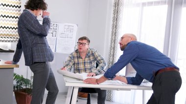 Üç adam bir mimarlık bürosunda birlikte çalışıyor. Şirketin yöneticisi, mühendisi ve avukatı projenin tahminlerini ve detaylarını tartışır. Bir grup insan elinde planlarla bir masanın etrafında toplandı.