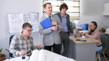 Genç ve dost canlısı bir takım. Şirketin yöneticisi ve avukatı sekreterin masasında durur ve şirketin baş mimarıyla iletişim kurarlar. Bir grup insan iş meselelerini tartışıyor.