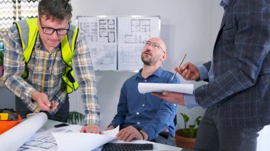 Tükenmiş. Yorgun patron çaresizce tavana bakar. Üç adam öfkeli bir şekilde modern bir iş merkezi inşa etme projesini tartışıyorlar. Ustabaşı ve mühendis fikirlere katkıda bulunuyor..