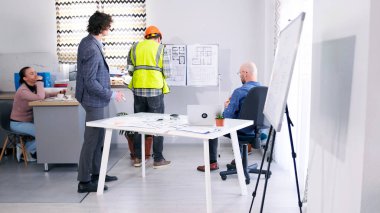 İnşaatçılar ve mimarlardan oluşan bir ekip akıllı bir ev projesini tartışıyor. Bir grup insan konferans odasında bir çizim tahtasında toplandı. İnşaat şirketinde brifing. İşbirliği ve odaklanma