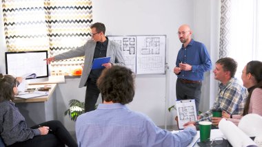 Bir inşaat şirketinin genç bir yöneticisi yeni bir tesis sunuyor. Şirket personeli inşaat fikirlerini tartışıyor. Bir grup insan, elinde çizimlerle toplantı odasında toplandı..