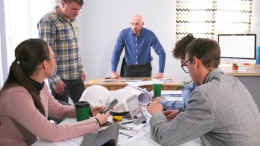 Öfkeli patron rahatsız edici çalışanı cezalandırır. İşten çıkarma ya da cezalandırma kavramı. Bir grup insan toplantı odasında bir masada oturuyor ve patronun tacizini dinliyor.