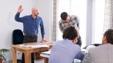 Patron astına saldırmak için sallanıyor. İşyerinde küfür ve hakaretler. Çalışanların işten çıkarılması kavramı. Şirketin personeli toplantı odasında bir masada oturuyor. Sahne ciddi ve odaklanmış.