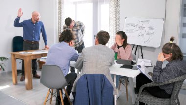 Şirket toplantısında sabah planlama seansı. Bir grup insan konferans odasında bir masada oturup patronun hakaretlerini dinliyor. Patron emrindekilerin işlerinden memnun değil..