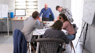Küçük bir inşaat şirketinde brifing. Bir grup ofis çalışanı konferans odasındaki bir masada oturuyorlar. Toplantı. Takım çalışması. Patron, meslektaşlarının önünde astını azarlıyor..