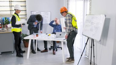 Bir inşaat şirketinden bir grup insan projenin ayrıntılarını ve bir iş merkezi inşaatının aşamalarını tartışıyor. Müteahhitler baş mimarın ofisinde. Proje için planları ve fikirleri tartışıyorlar..