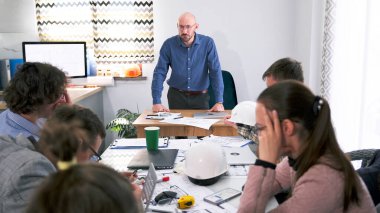 Kötü patron şu an toplantıda. Bir grup insan konferans salonunda bir masada oturuyor. Brifingde, önlerinde kızgın bir adam duruyor. Kimi kovacağına şirketin patronu karar verir ve grup dikkatlice dinler..