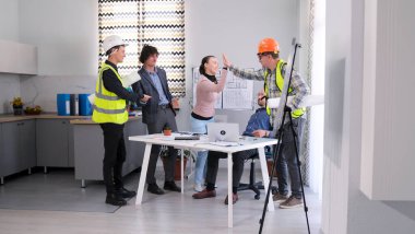 Mutlu inşaat şirketi çalışanları birbirlerine beşlik çakıyor. Bir grup insan rahat bir ofiste masanın etrafında toplandı ve ihaledeki zaferi kutladı. Sahne kaygısız ve eğlenceli.