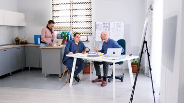 İnşaat mühendisi ofisindeki müşteriyle iletişim kurar. Bütçe ve inşaat planlarının koordinasyonu. Mimarlık Bürosu. Erkekler toplantı odasında sohbet ediyorlar..