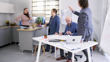 Bir grup meslektaşı projenin ayrıntılarını tartışmak için konferans odasında bir masanın etrafında toplandı. - Sekreter telefonda. Proje bütçesinin koordinasyonu. Atmosfer gergin görünüyor.