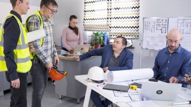 Bir inşaat şirketinin başkanı yeşil yelekli işçilerini cezalandırıyor. Ustabaşı ve bir arkadaşı inşaat alanındaki sorunları tartışmak için geldiler. Proje planlarını bir grup insan koordine edecek