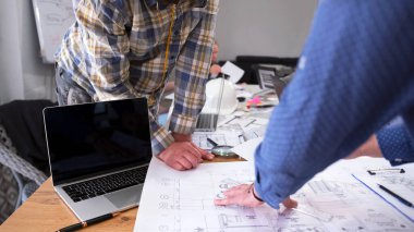 Bina çizimlerini tartışan iki adamın yakın çekimi. Bir mimar ve bir mühendis akıllı bir ev projesinde birlikte çalışıyorlar. Takım çalışması. Mimarlık Bürosu.