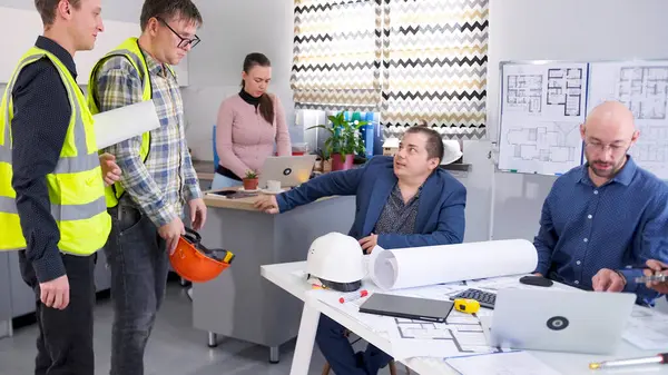 Bir inşaat şirketinin başkanı yeşil yelekli işçilerini cezalandırıyor. Ustabaşı ve bir arkadaşı inşaat alanındaki sorunları tartışmak için geldiler. Proje planlarını bir grup insan koordine edecek