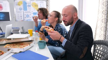 Kliniğin toplantı odasında üç kişi pizza yiyor. Lezzetli bir yemek. Mutlu ve aç çalışanlar sıcak bir mutfaktaki masada oturmuş pizza yiyorlar. Kahve molası