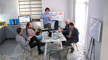 Şirketin genç şefi elinde kalın bir tomar para tutuyor ve onları faturaya saçıyor. Bir grup finansör şirketin kazancını rahat bir ofiste otururken hesaplar..