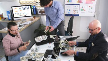 Muhasebeciler ve finansörlerden oluşan bir kooperatif ofise dağılmış nakit paraları sayıyor. Kârlı bir işe yatırım yapmak. Banka kredisi..