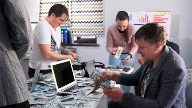 Adam ve meslektaşları parayı sayıyor. Bir grup arkadaş piyangoda büyük miktarda para kazandı. Sahne heyecan ve heyecanla dolu.