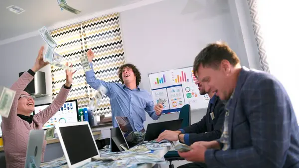 Küçük bir girişim zaferini pazara girerek kutluyor. Bir grup genç profesyonel ofis mutfağında oturuyor ve kağıt para saçıyorlar. Banka kredi onayı