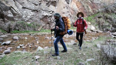 İki kardeş nehir kenarındaki kanyon boyunca yürüyorlar, etrafa bakınıyorlar ve doğanın manzarasının tadını çıkarıyorlar. Sırt çantalı hacılar kutsal bir yere gidiyorlar..