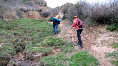 İki yolcu sırt çantalarıyla tepeye tırmanır. Bir grup adam yürüyüş turları için yeni bir rota araştırıyor. Erkekler doğada aktif olarak vakit geçirirler.
