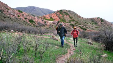 İki sıradan yolcu tepeler, çalılar ve kayalar arasında toprak bir dağ yolu boyunca yürüyorlar. Seyahat, yürüyüş ve özgürlük. Güzel doğa.