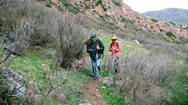 İki yorgun gezgin telefonlarındaki haritaya bakarak dağ yolunda yürüyorlar. Yürüyüş yaparken kayboldular ve cep telefonlarının güzergahını kontrol ettiler..