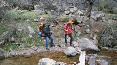 Elinde bira şişeleriyle ormanda yürüyen iki adam. Sırt çantalı bir grup adam nehir kıyısında kayalık bir yolda yürüyor ve bira içiyorlar. Seyahat.