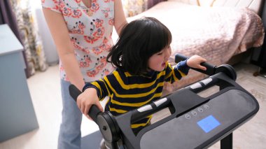 Bir kadın küçük bir kızın koşu bandında kalmasına yardım ediyor. Bekar bir anne kızıyla simülatörde koşar. Spor ve aktif bir yaşam tarzı. Annelik ve yetiştirilme