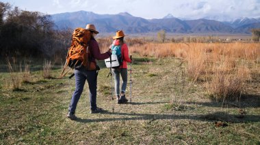 İki iyi arkadaş çimenli bir arazide yürüyorlar. Dişi hacılar dağlara gider. Öğrenciler dağlık bir bölgede seyahat ederler. Sahne sakin.