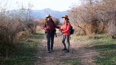 İki kadın yürüyüşçü daha sonraki rotayı tartışmak için toprak bir yolda duruyorlardı. Rahibeler birlikte seyahat ediyorlar. Gezginler uzun bir deniz gününden sonra dinleniyorlar. Gezinti ve yürüyüş