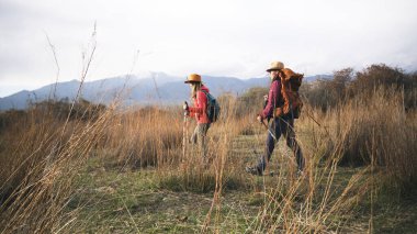 Uzun otlarla kaplı bir arazide iki kişi yürüyor. İki kız arkadaş dünyayı geziyor. Seyahat, macera ve özgürlük. Etkin hafta sonları.