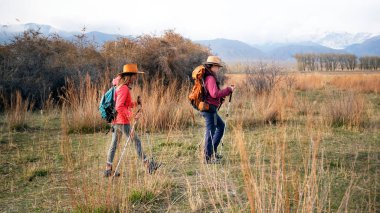 İki kadın romantik bir yürüyüş yapıyor. Sahne sakin ve huzurlu, kadınlar doğanın ve manzaranın güzelliğinin tadını çıkarıyor. Gezinti ve yürüyüş