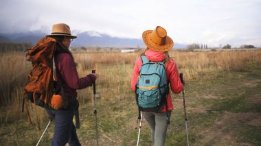 İki lezbiyenin romantik yürüyüşü. Sırt çantaları ve şapkalarla bir tarlada yürüyen iki kadın. Rehber kız arkadaşına yeni bir yol gösteriyor. Özgürlük ve seyahat