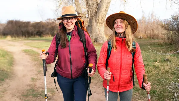 İki güzel genç kadın yolda yürüyor ve gülümsüyor. Yakın arkadaşlar kampta iyi eğlenceler. Lezbiyen çift gün batımında parkta yürür. Gezinti ve yürüyüş