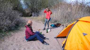 İki kadın yürüyüşçü sahilde bir çadırla uyandılar ve sosis kızartmak için şenlik ateşi yakacaklar. Deniz kenarında aktif bir hafta sonu. Uzun zamandır beklenen tatil.