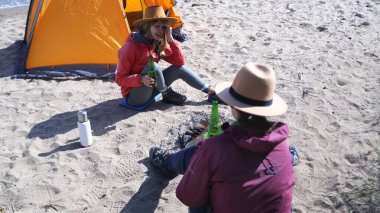 Kumsalda ellerinde bira şişeleriyle iki kişi oturuyor. Sahne rahat, iki en iyi arkadaş birbirinin arkadaşlığından ve güzel kumsaldan keyif alıyor..