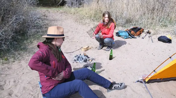 Bir grup turist piknik için plaja geldi. İki kadın deniz kenarında bir çadır kurdular ve şenlik ateşi yakıyorlar. Gezginler bira içer ve eğlenir.
