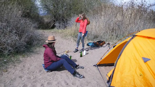 İki kadın yürüyüşçü sahilde bir çadırla uyandılar ve sosis kızartmak için şenlik ateşi yakacaklar. Deniz kenarında aktif bir hafta sonu. Uzun zamandır beklenen tatil.