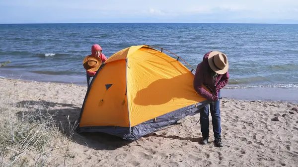 İki kadın sahilde çadır kurdu. Turistler deniz kenarında bir kamp yeri buldular. İki gezgin çadırı tamir ediyor. Macera, yürüyüş ve özgürlük.