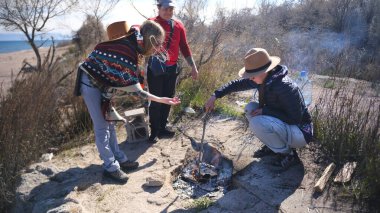 İki kız arkadaş ve arkadaşları sahilde şenlik ateşi yakıyorlar. Üç kişi deniz kenarında piknik yapmak için toplandı. Öğrenciler basit açık hava aktivitelerini severler. Arkadaşlar dinleniyor.