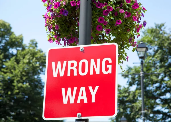 The red color \'wrong way\' sign with flowers on a lamppost in Halifax city (Nova Scotia, Canada).