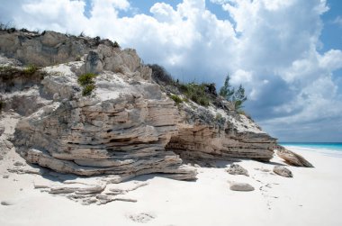 Yarım Ay Geçidi 'ndeki aşınmış kaya oluşumu ve kumlu boş bir plaj (Bahamalar)).