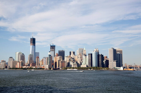 The view of Lower Manhattan skyline and a ferry boat passing by in Hudson River (New York City).