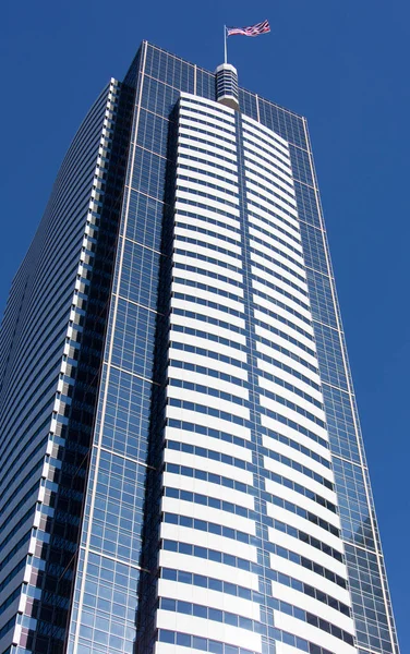 Ψηλός Σύγχρονος Ουρανοξύστης Μια Σημαία Μια Κορυφή Στο Κέντρο Του — Φωτογραφία Αρχείου