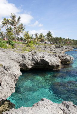 Turkuaz renk suları ve Mare Adası 'ndaki Tadine köyünde kayalık kıyılar aşınmıştır (Yeni Kaledonya).