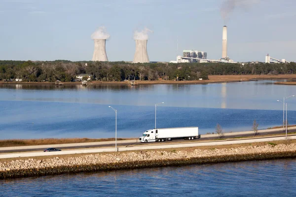 The evening view of a truck passing by and a power station in a background in Jacksonville city (Florida).